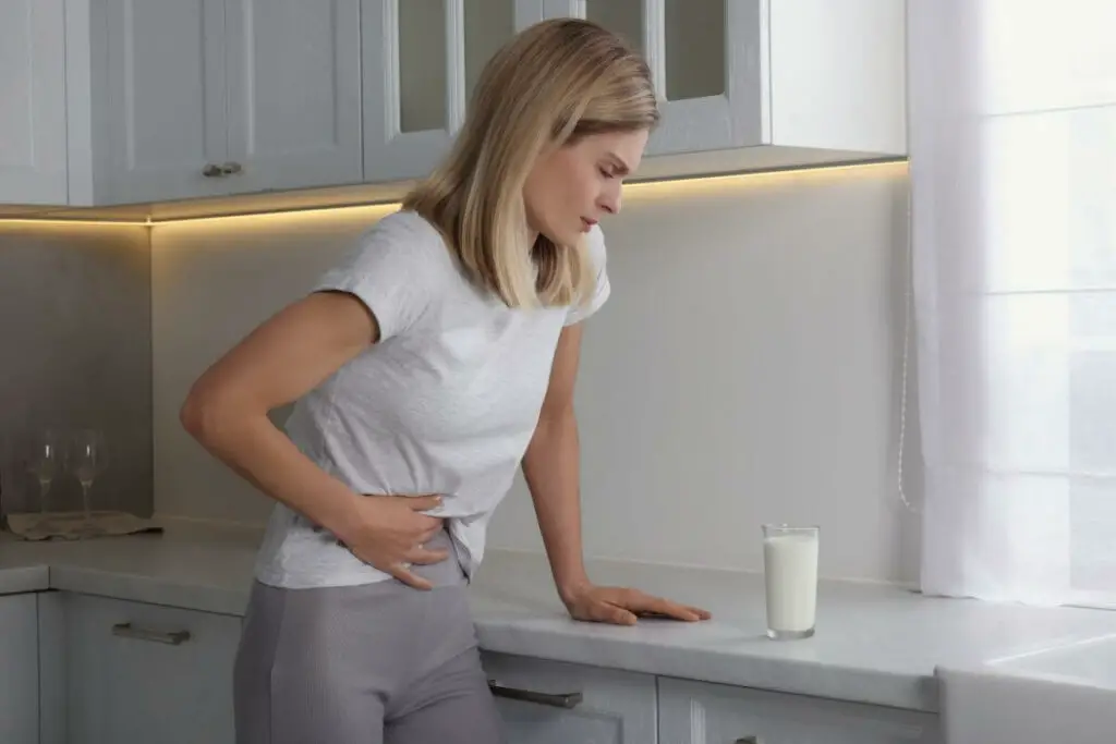 A woman with irritable bowel syndrome (IBS) looking at a glass of milk.