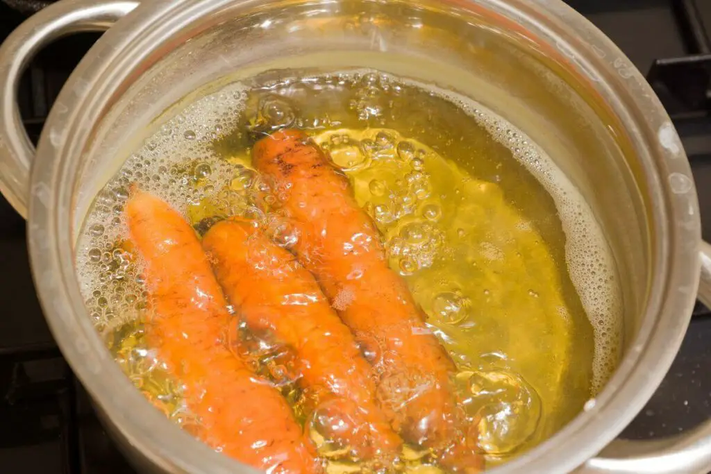 The vegetables are being cooked in a pot of oil.