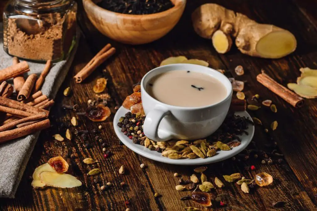 A cup of tea with cinnamon and spices, perfect for those looking for the best drinks for IBS, placed on a rustic wooden table.