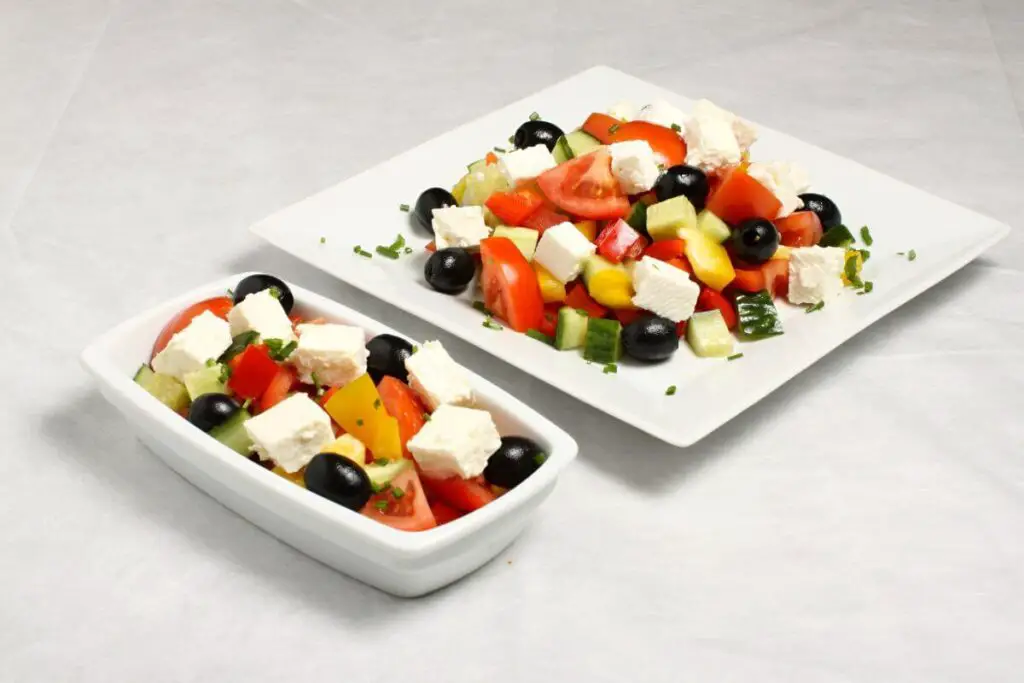 A plate of salad with feta cheese, tomatoes and olives - the best snacks for IBS!