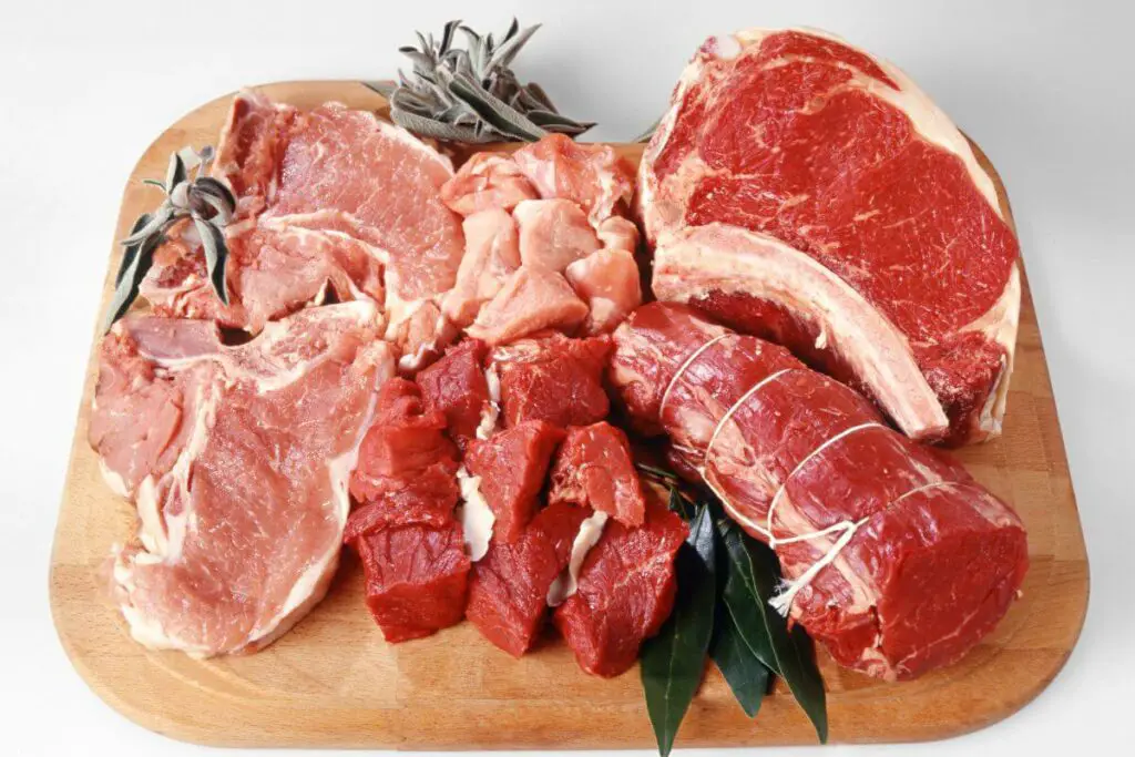 Assorted cuts of meat on a wooden cutting board, suitable for individuals with IBS.
