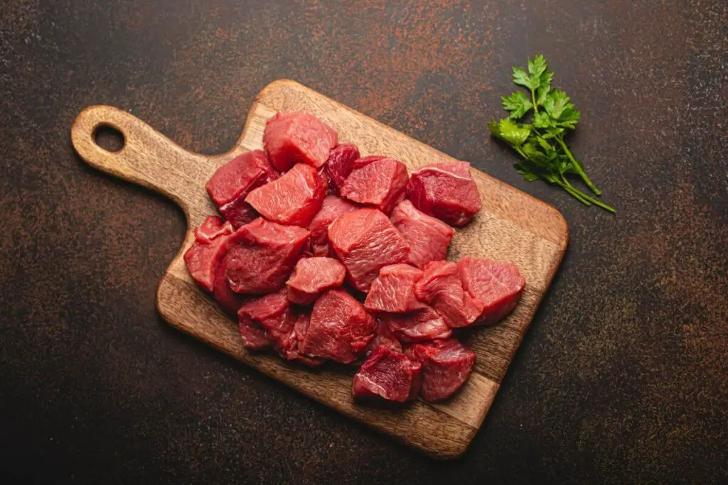 The appetizing image showcases a piece of raw meat on a cutting board, accompanied by a sprinkling of fresh parsley.