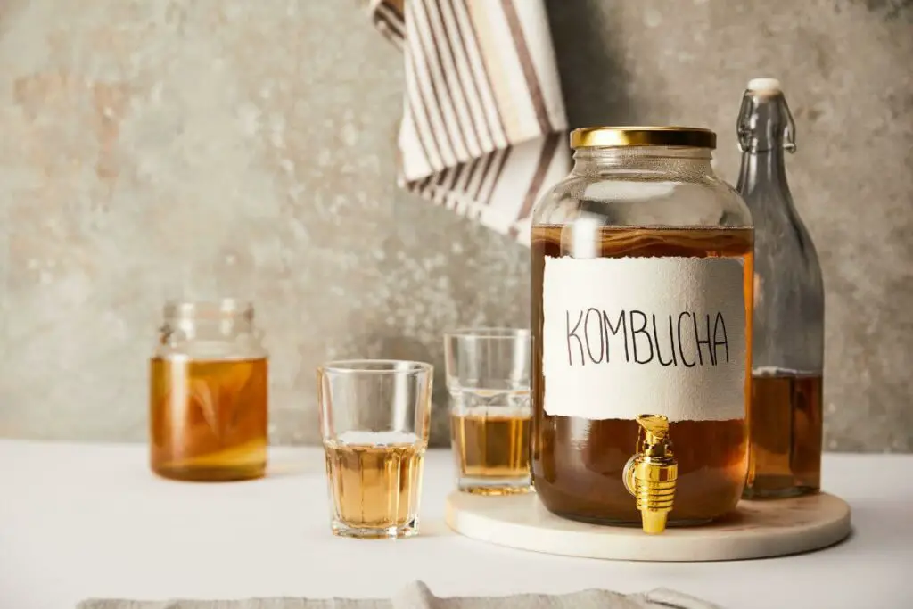 A jar of kombucha, one of the best drinks for IBS, sitting on a table.