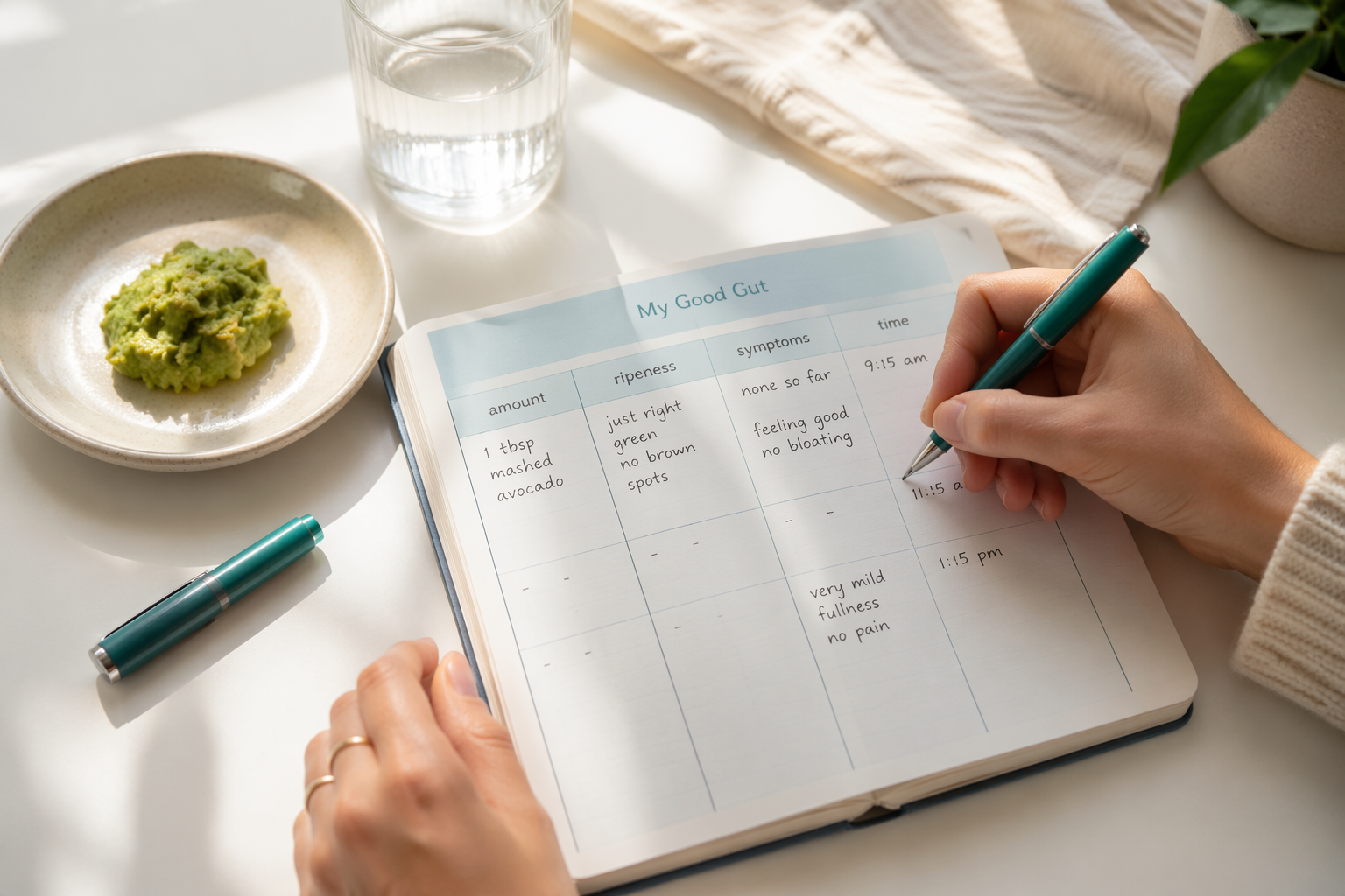 Hands writing an avocado testing food journal with measured portion and notes