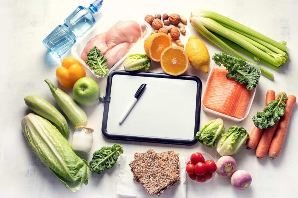 A white board covered in fruits and vegetables.