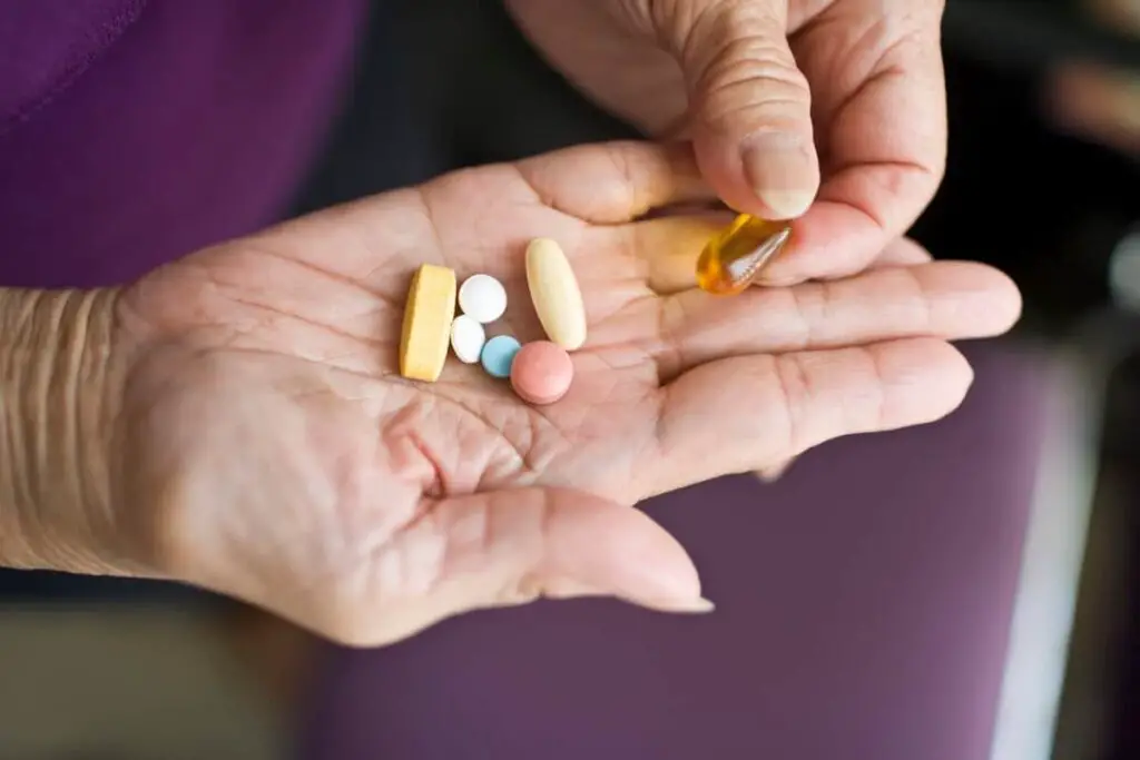 A woman holding pills in her hand.